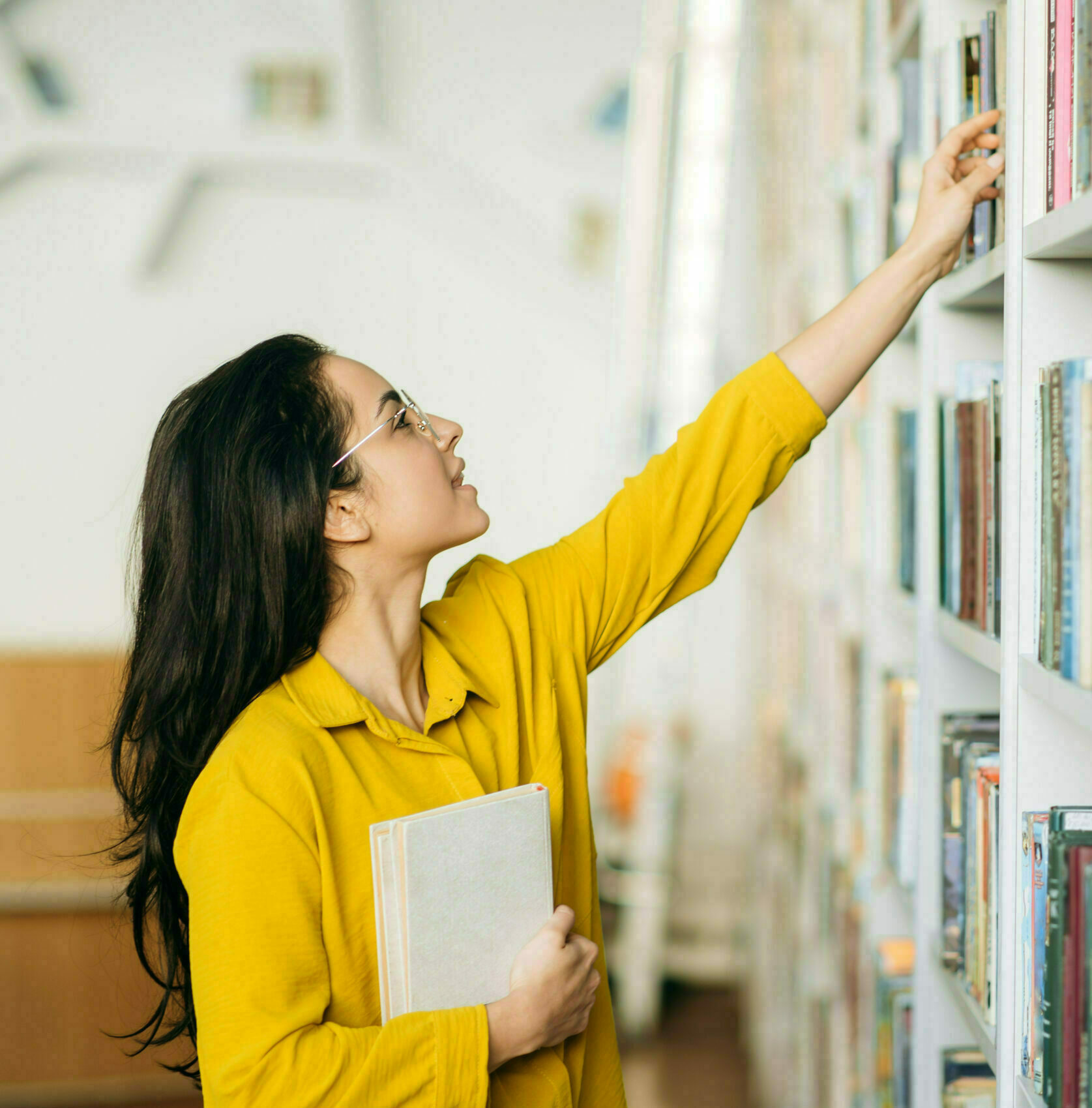 Caucasian,Female,Student,Stands,In,University,Library,,Looking,For,A