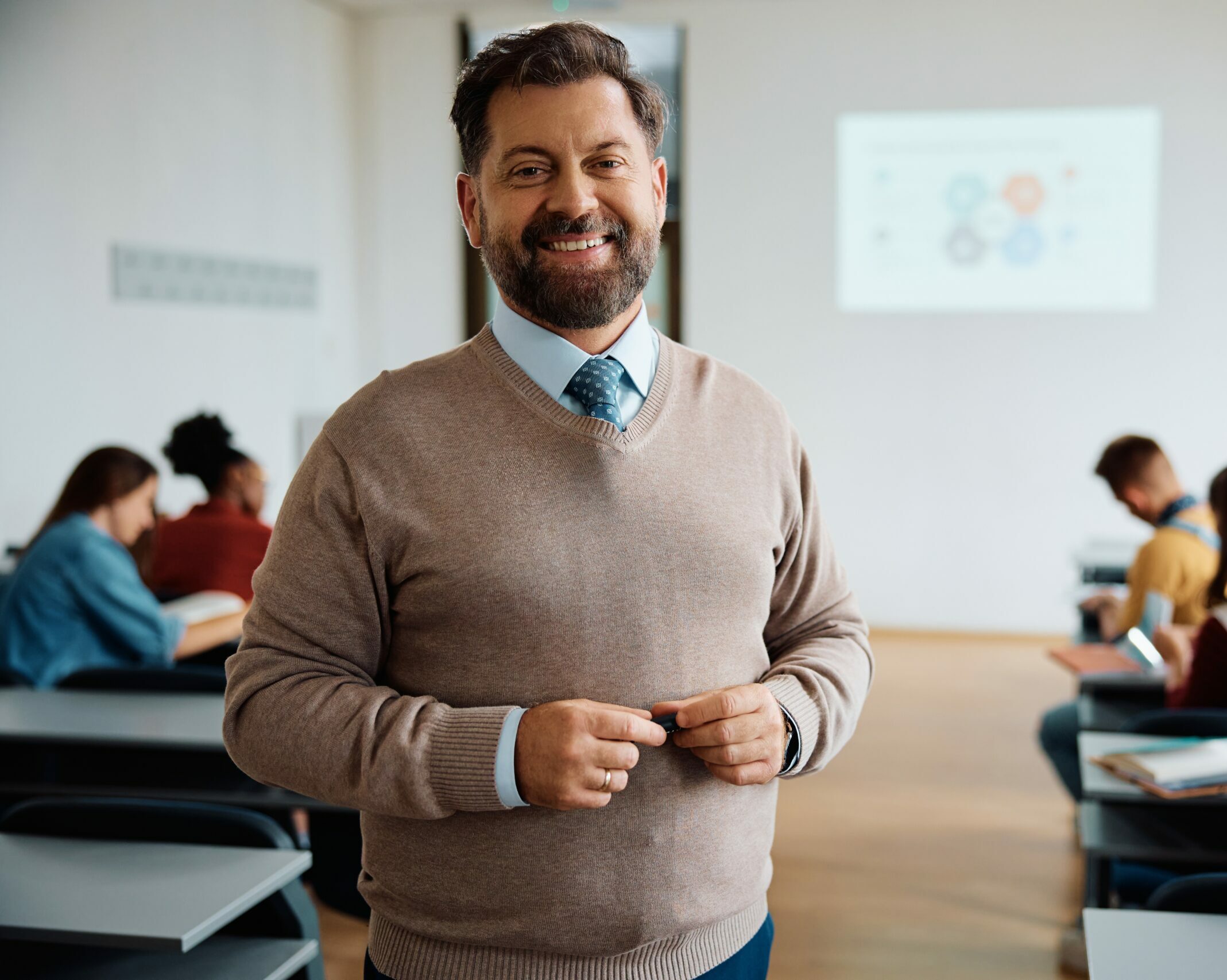 Portrait,Of,Happy,University,Teacher,In,The,Classroom,Looking,At